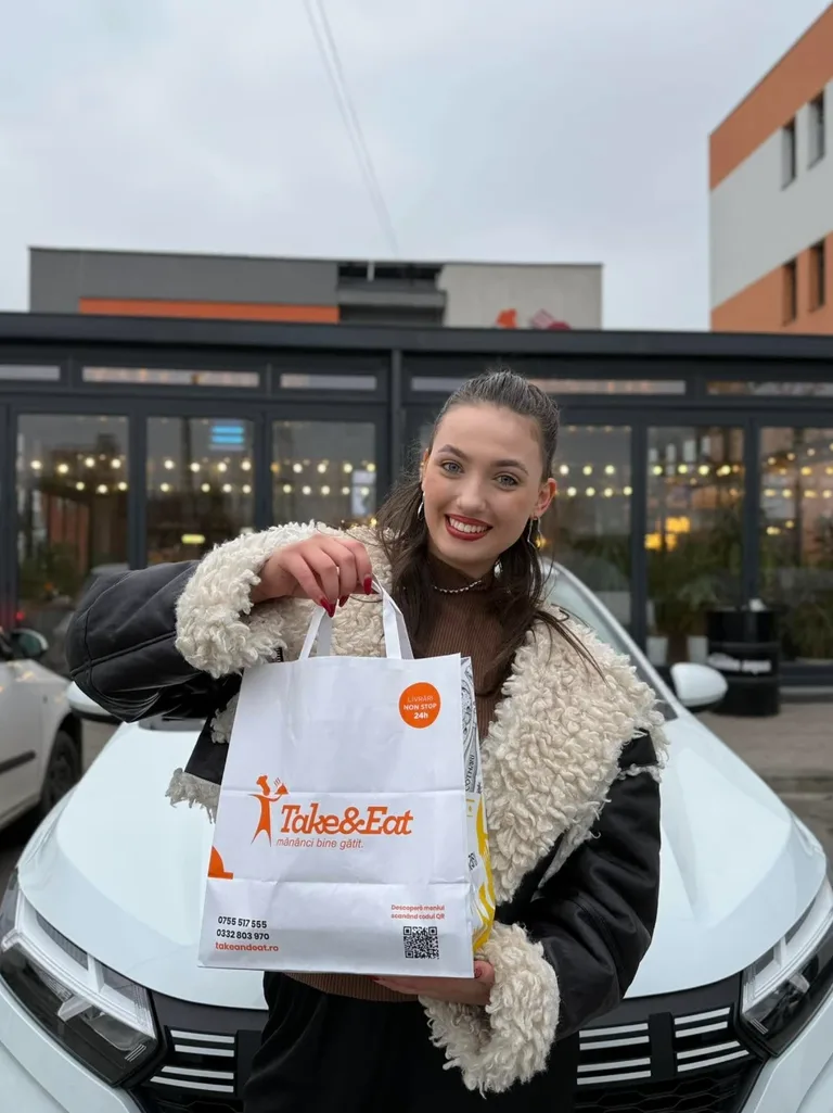 Clientă cu o comandă Take&Eat, în fața restaurantului